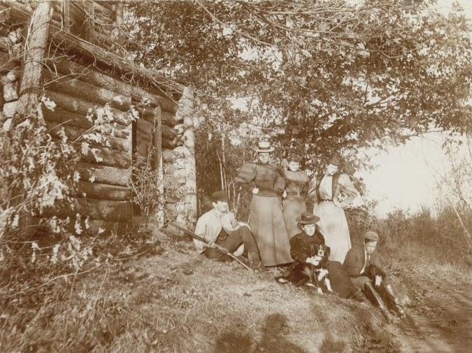Group of people in front of cabin.