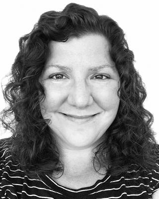 black and white headshot of a smiling woman with dark hair