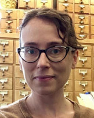 photo of April Collins with a library card catalog in the background