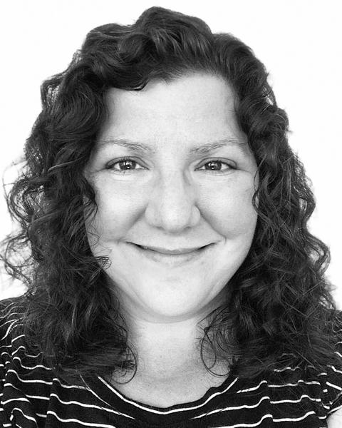 black and white headshot of a smiling woman with dark hair